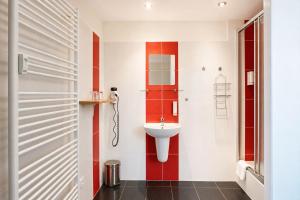 a bathroom with red and white walls and a sink at Hotel CHODOV ASC in Prague