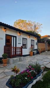 a small white house with flowers in front of it at Pousada jade in Pirenópolis