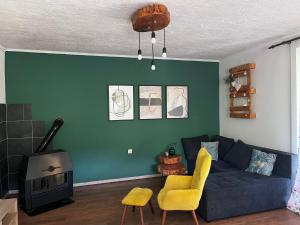 a living room with a blue couch and a fireplace at Kuća za odmor ANAMARIJA in Ogulin