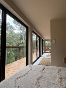 a bedroom with large windows and a view of a deck at Domaine d'Olga - Lodges & SPA in Aniane +19 photos