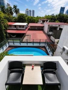 a balcony with a table and chairs and a swimming pool at Panama Experience Hostal in Panama City