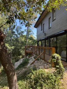 a house with a deck next to a building at Domaine d'Olga - Lodges & SPA in Aniane