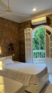 a bedroom with a bed and a stone wall at luxor nile palace in Luxor +35 photos