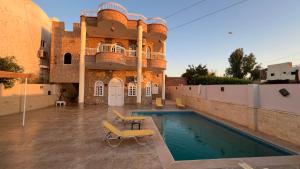 a house with a swimming pool and a building at luxor nile palace in Luxor