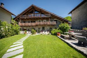 an exterior view of a house with a green yard at Granuit room & breakfast in Sauze di Cesana