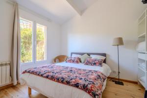 a bedroom with a bed and a window at Chalet Cosy in Lège-Cap-Ferret