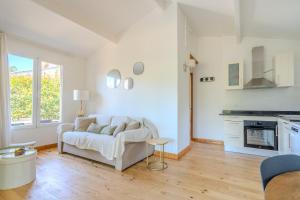 a white living room with a couch and a table at Chalet Cosy in Lège-Cap-Ferret