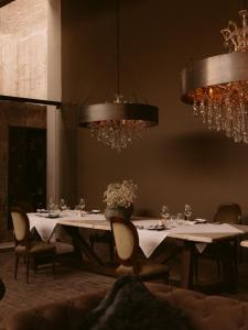 a dining room with tables and chairs and chandeliers at CIRQA - Relais & Châteaux in Arequipa