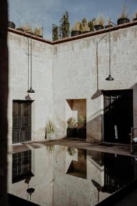 a brick building with a reflection in the water at CIRQA - Relais & Châteaux in Arequipa