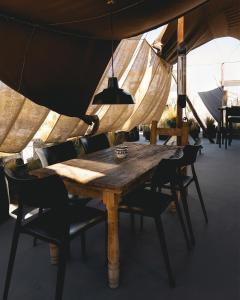 a wooden table and chairs under a tent at CIRQA - Relais & Châteaux in Arequipa