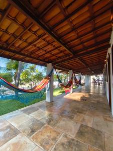 a porch with a hammock hanging from the ceiling at Villa Tarifa Suites in Amontada