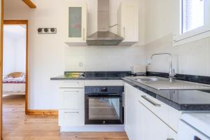 a kitchen with a sink and a stove top oven at Chalet Cosy in Lège-Cap-Ferret +20 photos