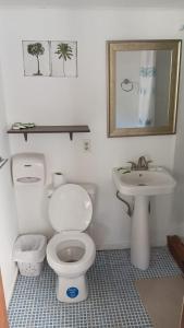 a bathroom with a toilet and a sink at Las Palmas Beach Roatan in Dixon Cove