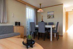 a living room with a dining room table and chairs at chalet de kievit in Serooskerke