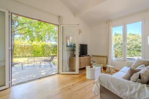 a living room with a couch and a sliding glass door at Chalet Cosy in Lège-Cap-Ferret
