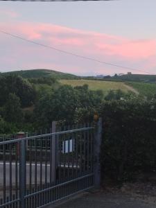 a gate with a view of a field at Dimora Gundin in Govone