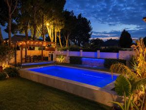 a swimming pool in a backyard at night at Lou Meinado, un concept "comme à l'hôtel" in Saint-Martin-de-Crau +17 photos