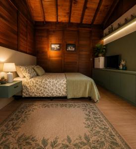 a bedroom with a bed in a room with wooden walls at Refúgio Rural Ipê Lago e Fogueira ao Ar Livre in Campo Alegre