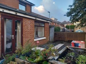 a brick house with a garden in front of it at Divis street guest house in Belfast