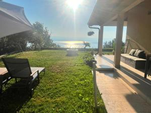 a porch of a house with a chair and the ocean at Room Lina in Lovran