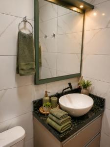 a bathroom with a sink and a mirror at Refúgio Rural Ipê Lago e Fogueira ao Ar Livre in Campo Alegre