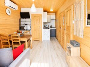 a kitchen and a living room with a table and chairs at Domki nad Soliną 665-189-444 OGRZEWANE in Solina +7 photos