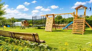 a park with a bench and a playground at Domki nad Soliną 665-189-444 OGRZEWANE in Solina