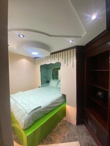 a bedroom with a bed with a green headboard at Panama Experience Hostal in Panama City