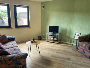 a living room with two couches and a flat screen tv at Ferienhaus an der Felsenkirche in Idar-Oberstein