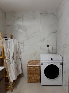 a white laundry room with a washing machine at Emerald Dream Oasis Studio in Skala Potamias