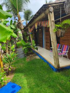 a house with two chairs on the porch of it at Mandala House - Kite Village in Icaraí