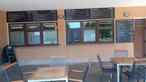 a dining room with tables and chairs and signs at Penzion Pristav in Lipno nad Vltavou