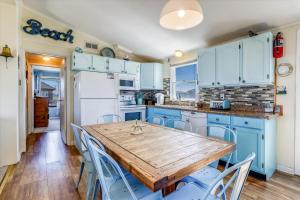 a kitchen with blue cabinets and a wooden table and chairs at 5010 - Once Upon A Tide in Kill Devil Hills