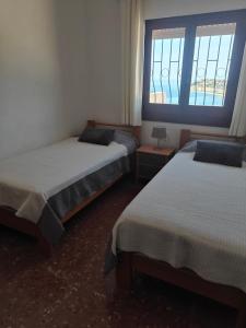 a bedroom with two beds and a window at La Perla in Almuñécar +19 photos