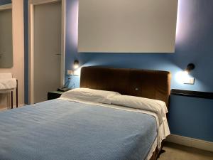 a bedroom with a bed with a blue wall at Hotel Calypso in Milan