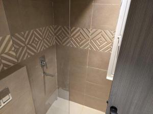 a bathroom with a shower with a glass door at SriVa Nest in Ghaziabad +4 photos