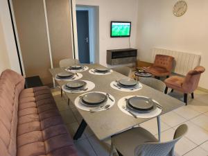 a living room with a table and a couch at NEW! Appartement PrixMalin 1 à 7 personnes in Champagnole