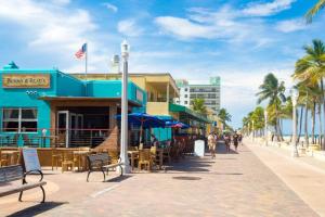 a street with tables and chairs and a blue building at Luxury Private Studio King Bed Free Parking in Miramar