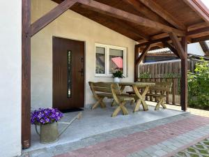 a patio with a wooden table and two benches at U Zgagi in Mikoszewo