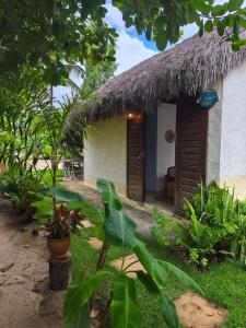 a small house with a thatch roof at Tiny Cottage in Icaraí