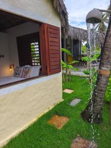 a house with a water fountain in the yard at Tiny Cottage in Icaraí