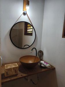 a bathroom with a bowl sink and a mirror at Tiny Cottage in Icaraí