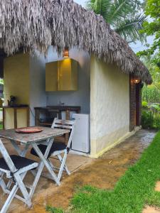 a house with a table and a kitchen in front of it at Tiny Cottage in Icaraí
