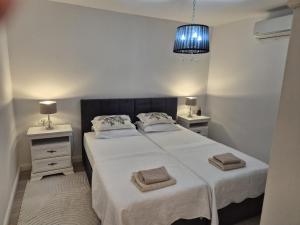 a bedroom with a bed with two night stands and a blue light at Apartman Sanja in Ploče