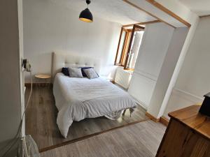 a bedroom with a bed with white blankets and pillows at relais de la diligence in Morteau