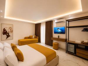 a hotel room with a bed and a television at Dine Hotel in Ksamil
