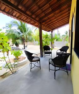 a group of chairs sitting on a patio at Villa of the Palm Trees in Icaraí
