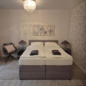 a bedroom with a bed and two lamps and a chandelier at Landwiese in Landkern