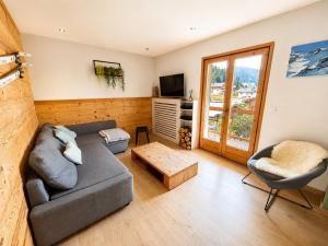 a living room with a couch and a tv at *** Le Refuge *** Logement standing Megève in Demi-Quartier
