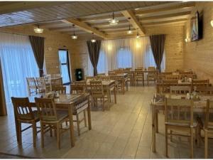 a dining room with wooden tables and chairs at Casa Mocanitei in Vişeu de Sus